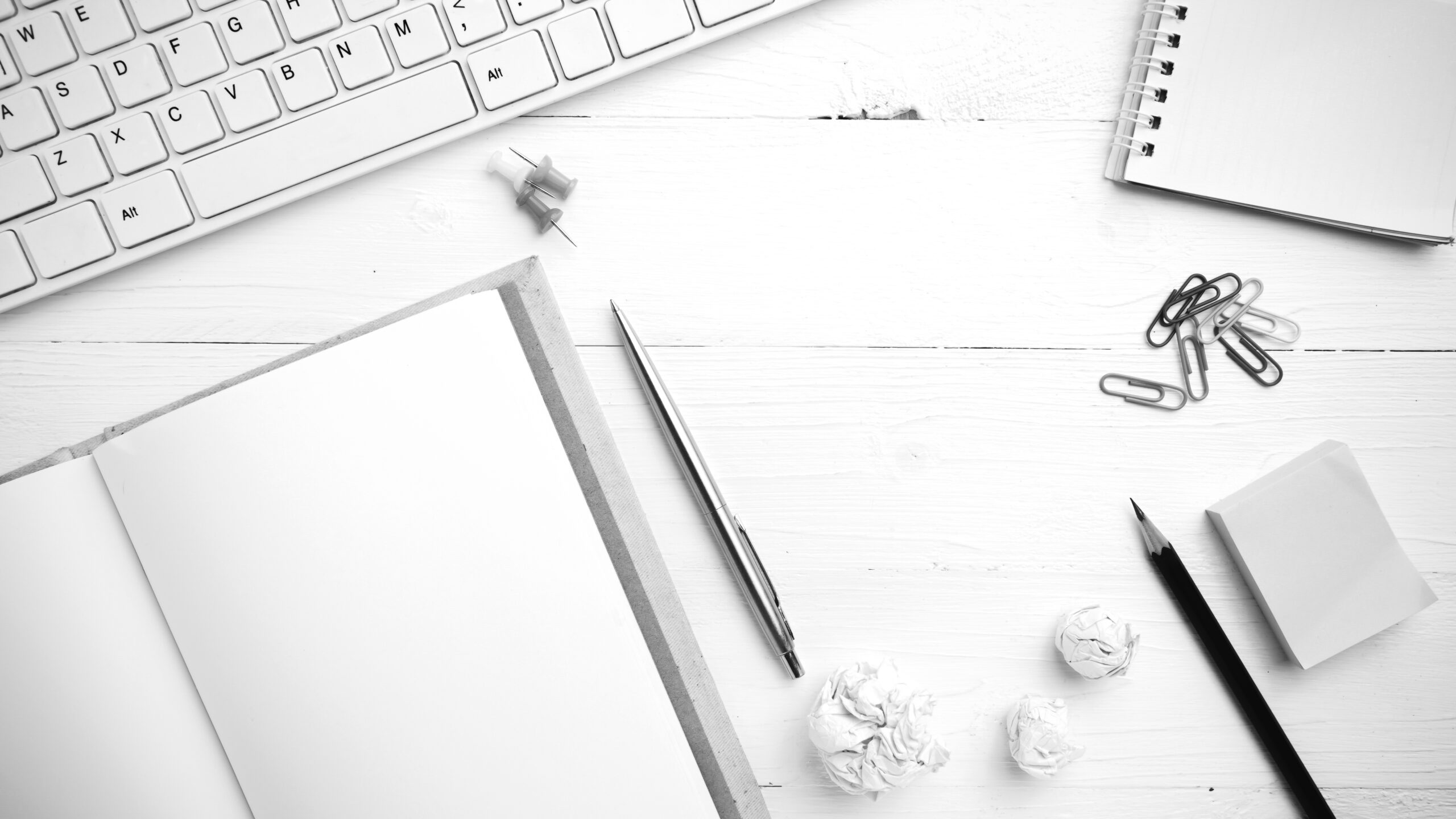 computer and notebook with office supplies black and white tone