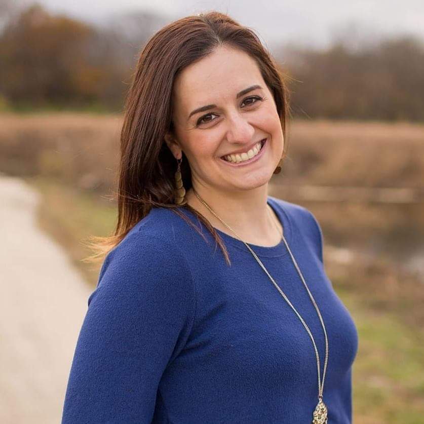 headshot of a woman in a blue shirt